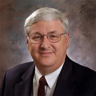 a photo of a man on a gray-purple background.