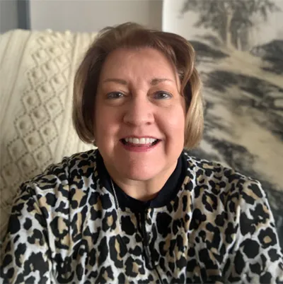 a photo of a woman sitting in front of a painting