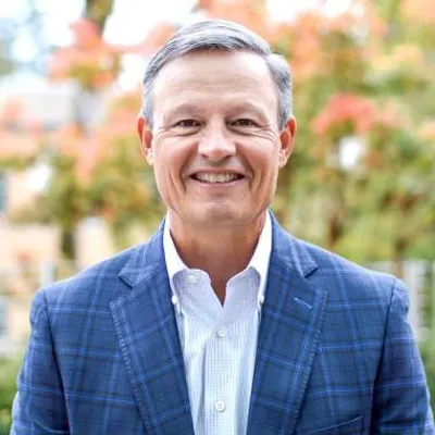 a photo of a man in front of some trees