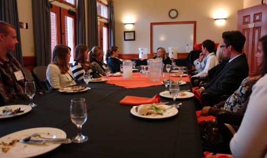 Students sit at table with Austin Fellow at the head