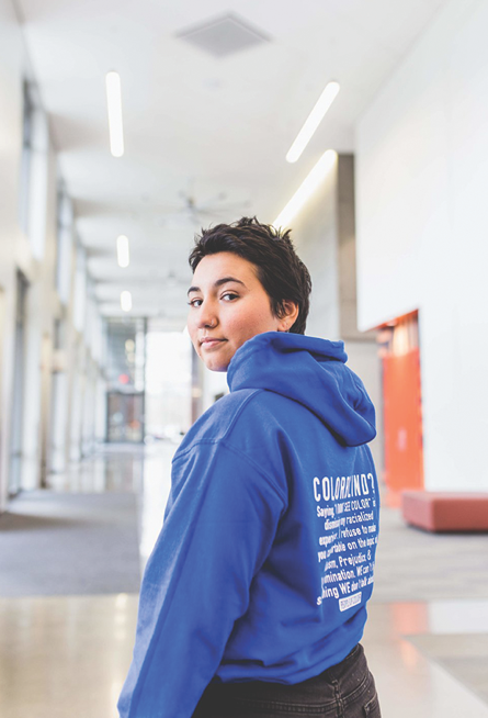 A woman poses with her People of Color sweatshirt