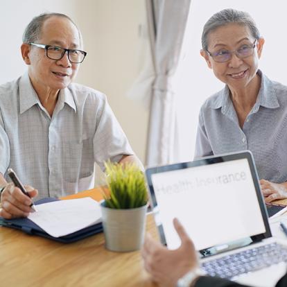 A person with a laptop speaking to two people listening