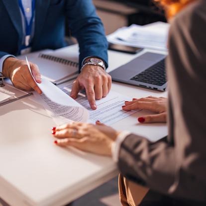 two people signing a contract