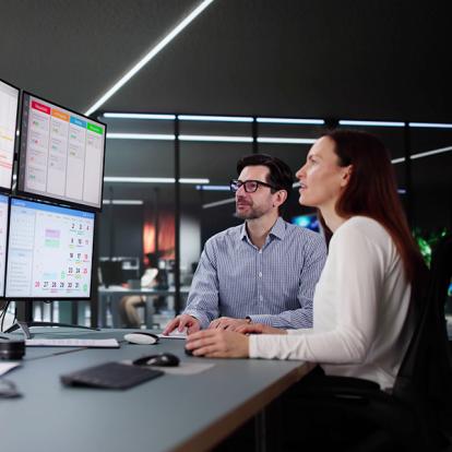 two people looking at a set of computer screens