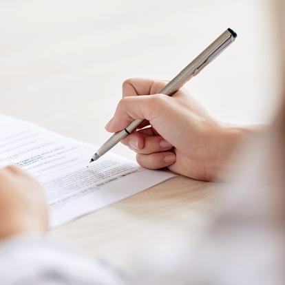 a person hovering a men over a piece of paper