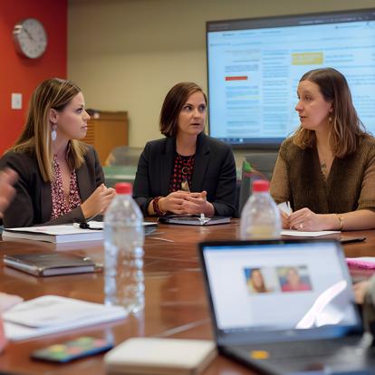 a group of women working around a table in front of a projector