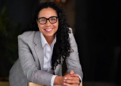 Photo of Bianca Williams wearing a light gray blazer and glasses