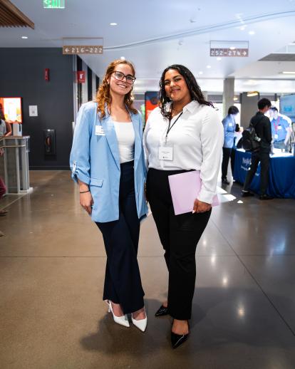 Two women standing alongside each other, posing for a photo