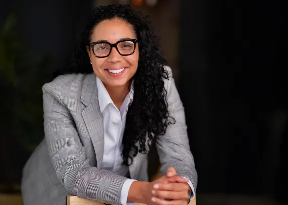 Photo of Bianca Williams wearing a light gray blazer and glasses