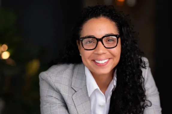 Portrait of Bianca Williams, who is wearing a gray blazer and glasses