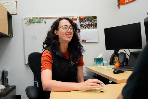 A female advisor smiling while offering support to a student