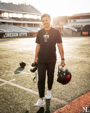 student on football field with camera