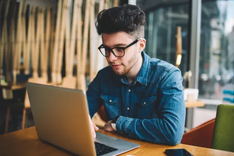 young man studying on a laptop
